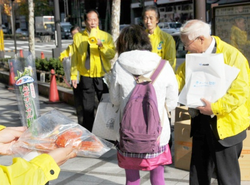 歩行者にセイコガニや水仙を配りＰＲする越前町議員＝２９日、京都市