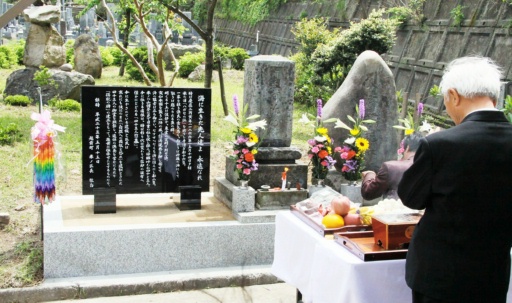 事故当時に建立された共同墓（中央）と、４３人の法名を刻んだ新たな石碑（左）の前で営まれた供養祭＝１５日、福井県越前町米ノ