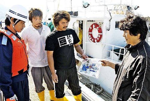 漁師にライフジャケットの着用を呼び掛けるＬＧＬメンバー（右）＝２８日、福井県越前町小樟
