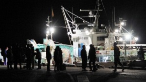 家族らが見守る中、今季初の越前がに漁に出港する漁師たち＝５日夜、福井県越前町の越前漁港