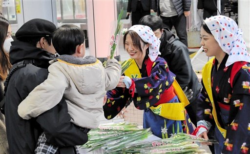 来場者に水仙を手渡す水仙娘